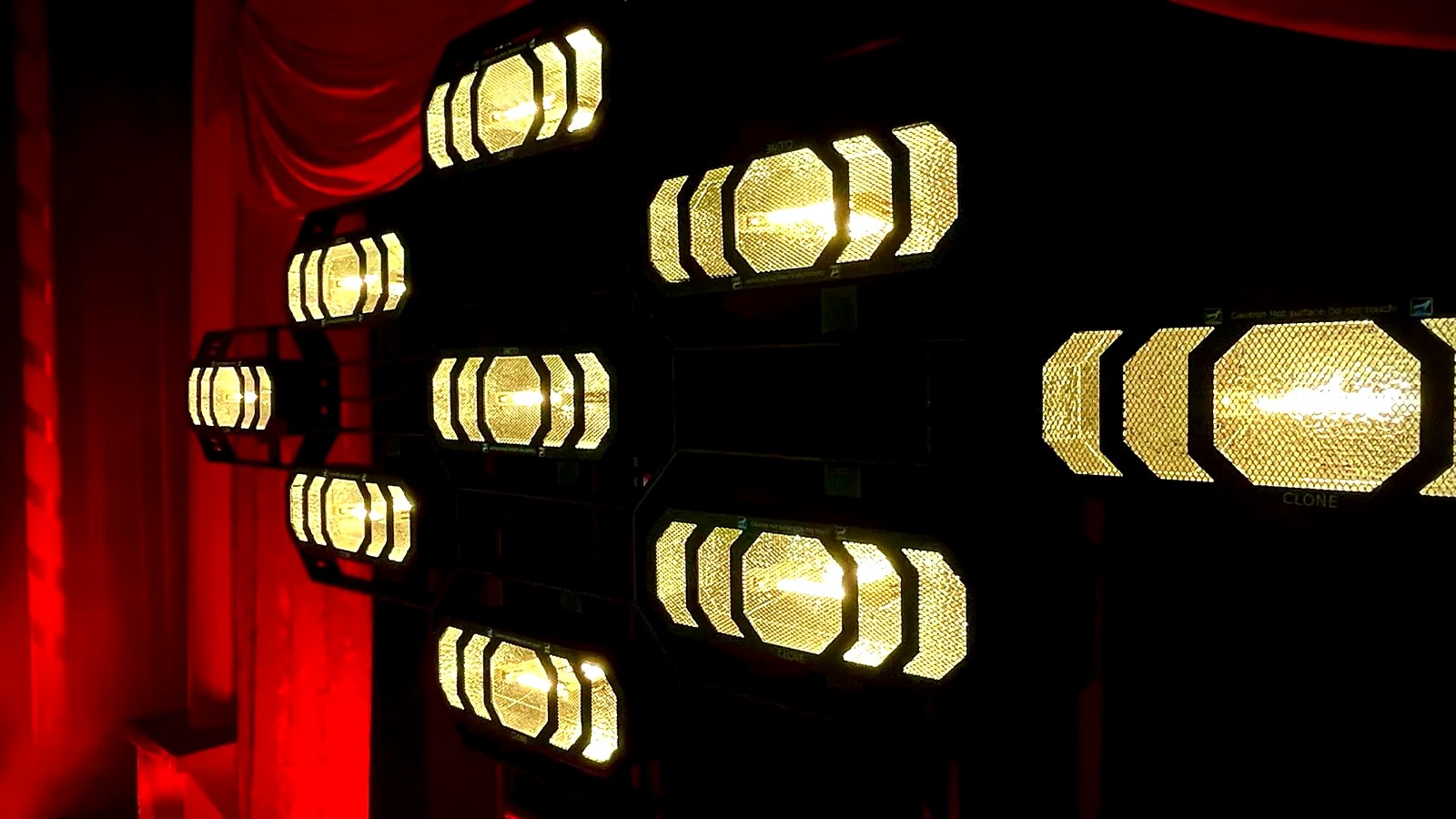 Decoratief podiumlicht met warme lichtarmaturen en rode gordijnen